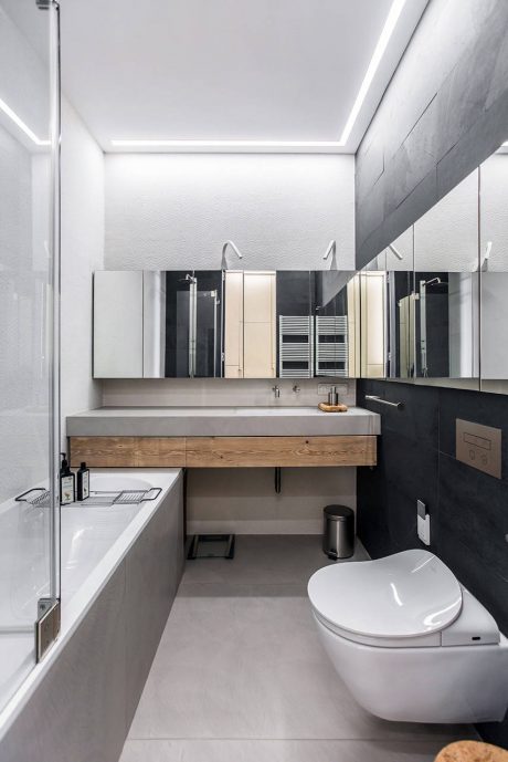 Minimalist bathroom design with concrete vanity, recessed lighting, and sleek fixtures.