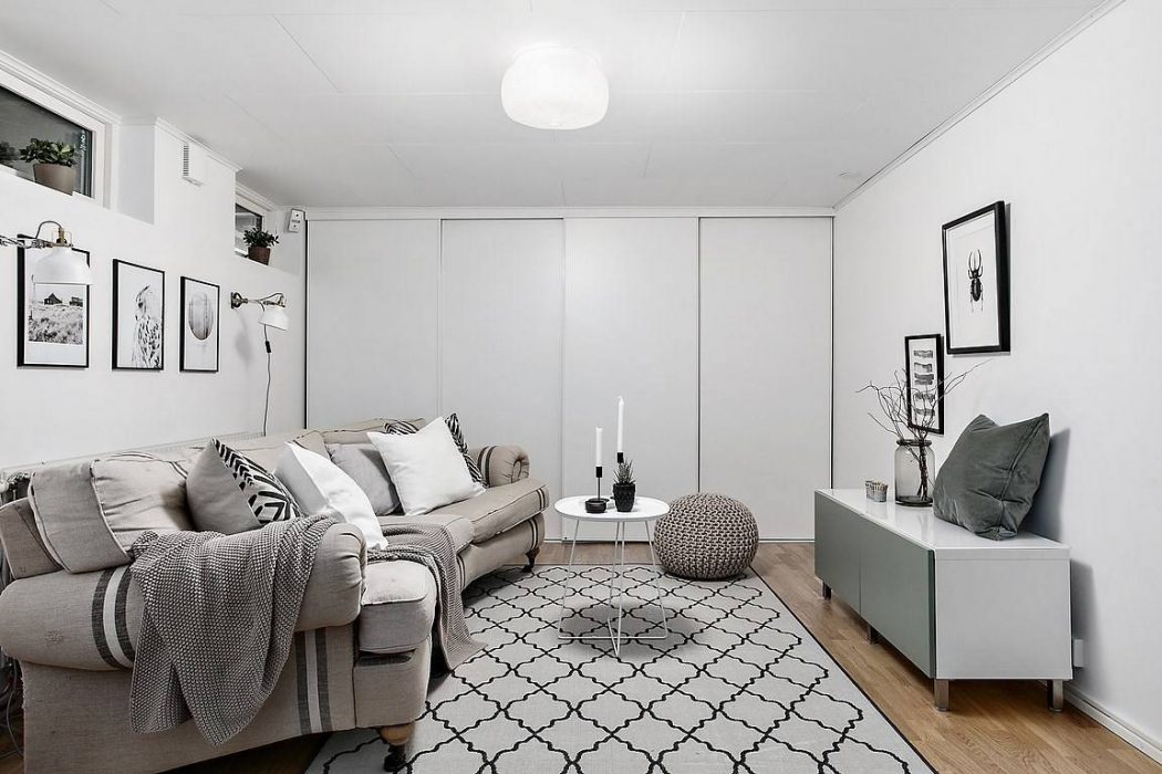 Minimalist living room with monochrome decor, patterned rug, and geometric accents.