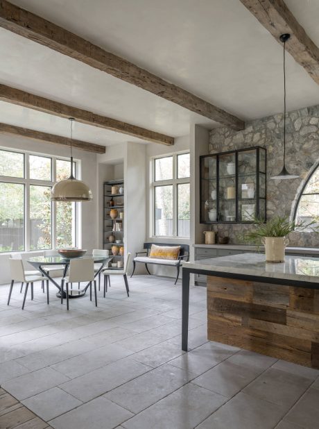 Rustic wooden beams, stone walls, and modern furnishings create a cozy, inviting space.