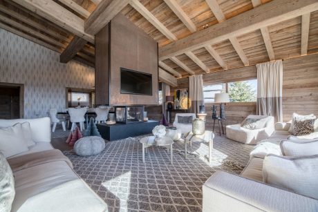 Cozy cabin with rustic wood beams, plush seating, and modern decor elements.