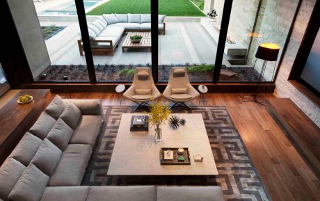 Luxurious open-concept living space with sleek modern furnishings and lush outdoor views.