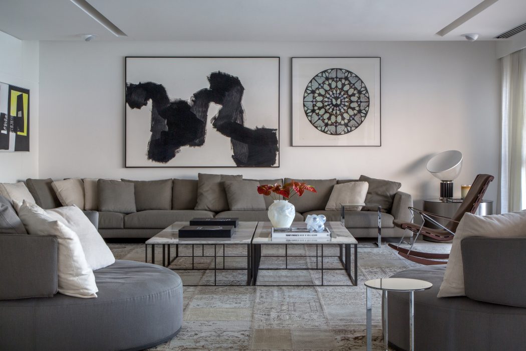 Sleek, modern living room with abstract artwork, geometric coffee table, and cozy sectional sofa.