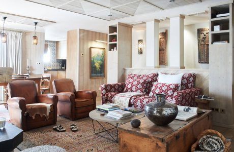 A cozy, rustic living room with wooden furniture, patterned fabrics, and decorative accents.