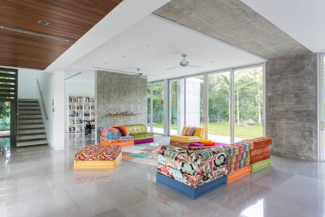 A modern, open-plan living space with vibrant, patterned furnishings and expansive windows.