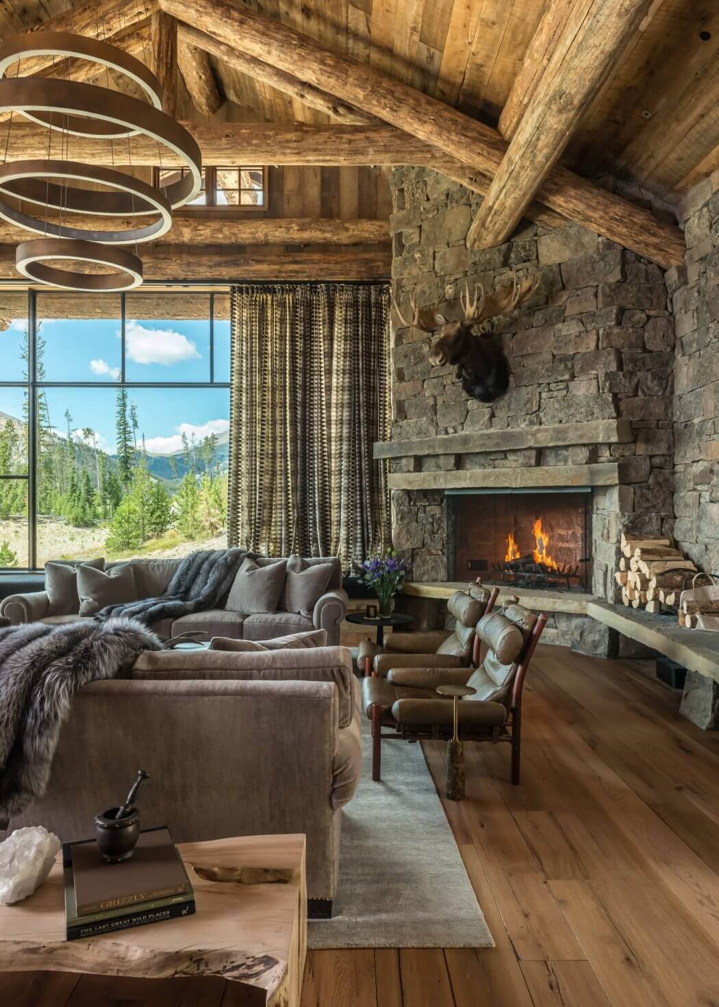 Rustic living room with stone fireplace, wooden beams, and cozy furnishings.