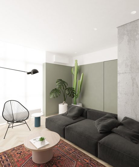 A modern, minimalist living room with concrete walls, a large dark sofa, and potted plants.