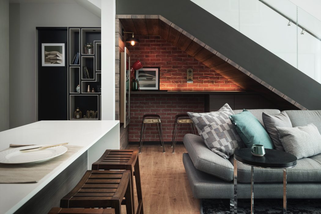 Cozy loft with exposed brick, built-in shelving, and modern furnishings.