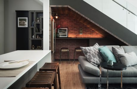 Cozy loft with exposed brick, built-in shelving, and modern furnishings.