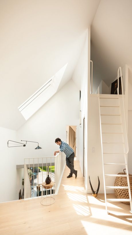 A modern, minimalist interior with clean lines, natural lighting, and a spiral staircase.