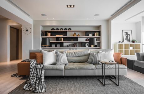 Minimalist living room with built-in shelves, plush gray sofa, and accent decor.