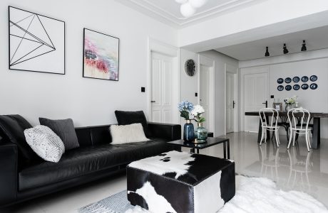 A modern, stylish living room with monochromatic decor and geometric artwork.