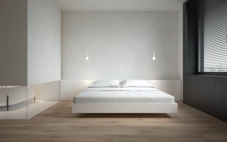 Minimalist bedroom with a floating bed, white walls, and wood flooring.