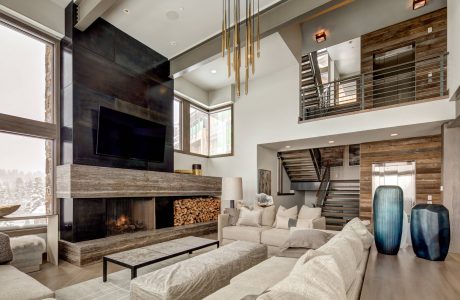 Modern rustic living room with fireplace, reclaimed wood accents, and sleek lighting.