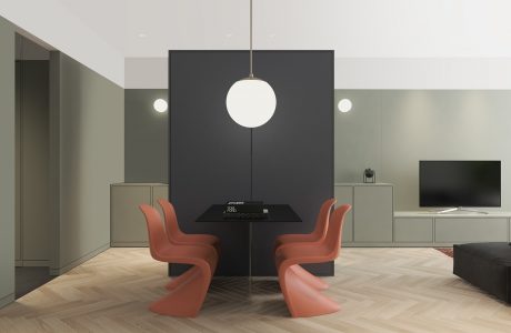 Minimalist living room with pendant light, black table, and modern coral chairs.