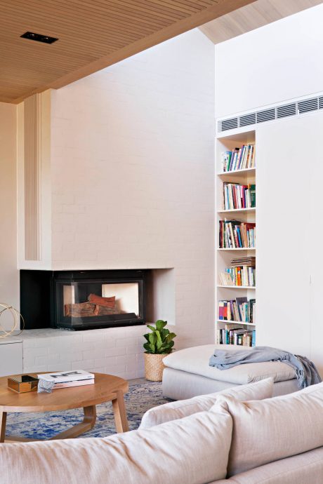 Cozy living room with fireplace, built-in bookshelves, and wood furnishings.