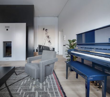 Sleek, modern room with a striking blue piano and abstract artwork on the walls.