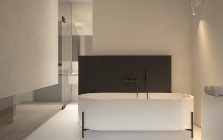 Modern minimalist bathroom with freestanding bathtub, dark accent wall, and recessed lighting.
