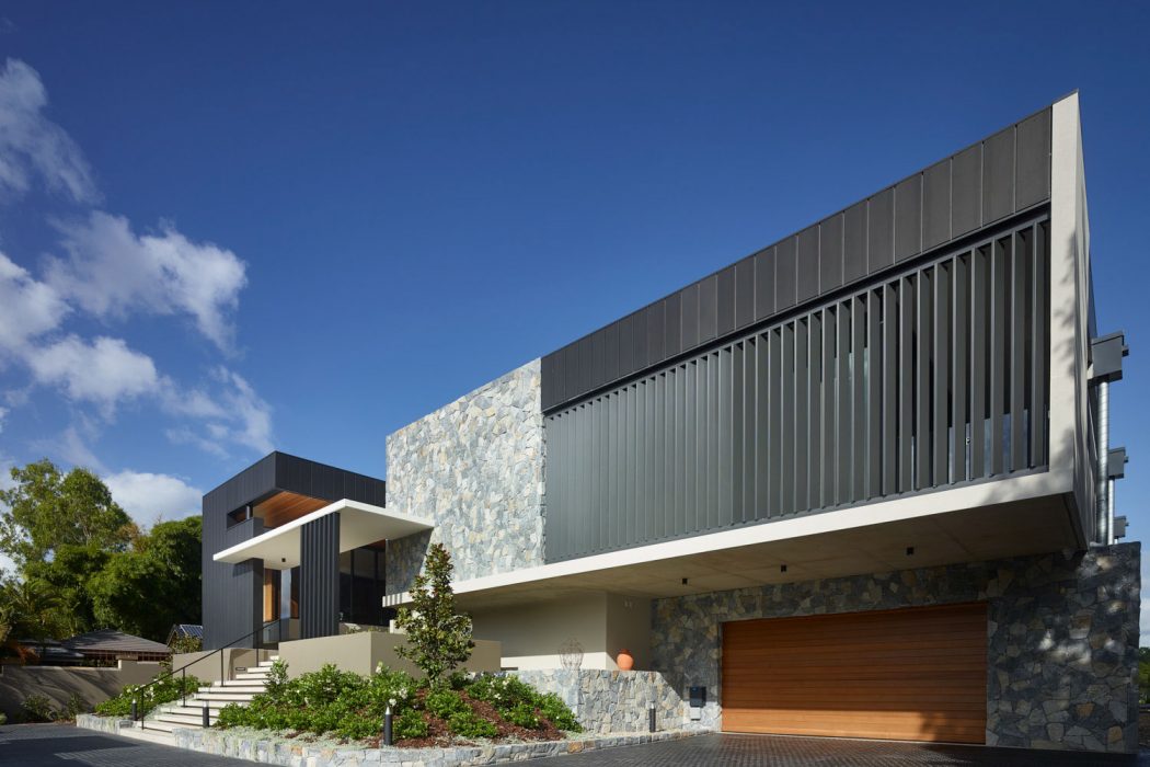 Modern architectural design with stone and steel elements, contrasting textures and shapes.