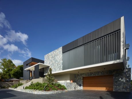 Modern architectural design with stone and steel elements, contrasting textures and shapes.