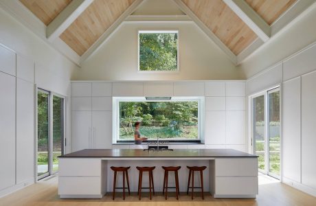 Spacious open-concept kitchen with vaulted ceiling, large windows, and modern island seating.