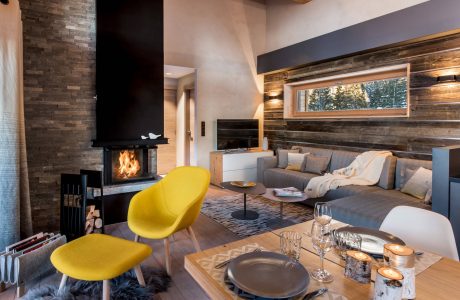 Cozy mountain lodge living room with rustic wood accents, plush seating, and a fireplace.