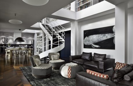 Sleek, modern interior with spiral staircase, black leather furniture, and large artwork.