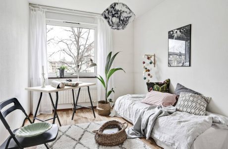 Cozy bedroom with modern furnishings, large window, and nature-inspired decor elements.