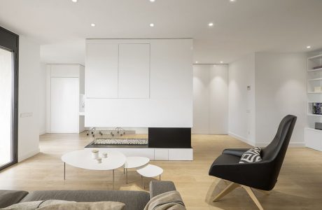 Minimalist living room with white walls, built-in storage, and a sleek fireplace centerpiece.