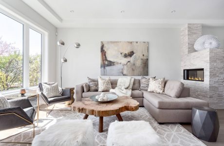 A cozy and inviting living room with a contemporary fireplace, plush seating, and abstract artwork.