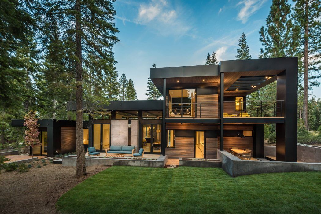 Contemporary mountain cabin with wood, steel, and glass elements; outdoor patio and landscaping.