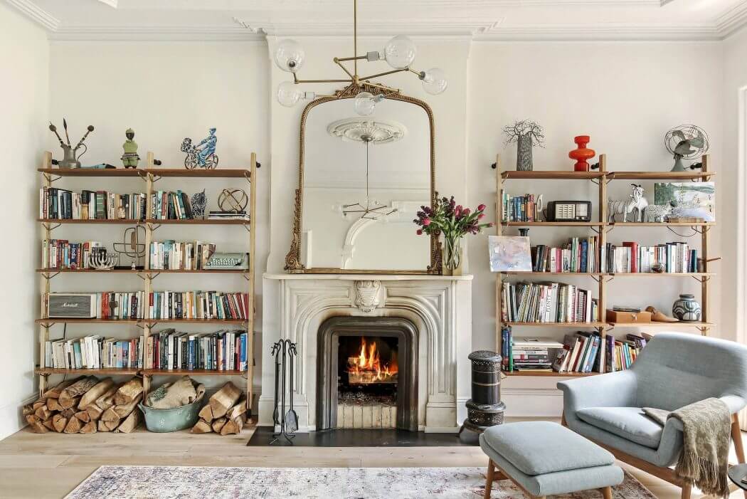 A cozy, well-lit living room with built-in bookshelves, a decorative fireplace, and a stylish mix of furnishings.