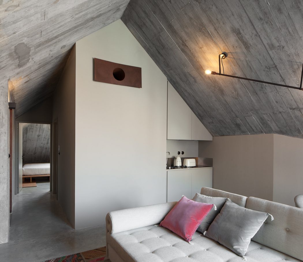 Cozy cabin interior with wooden walls, sloped ceiling, and minimalist furnishings.