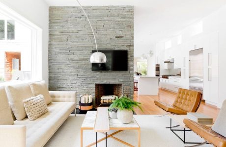 A modern living space with a stone accent wall, minimalist furnishings, and natural light.