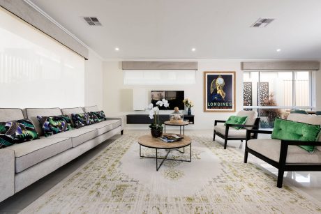 Spacious living room with modern furniture, artwork, and light wood coffee table.