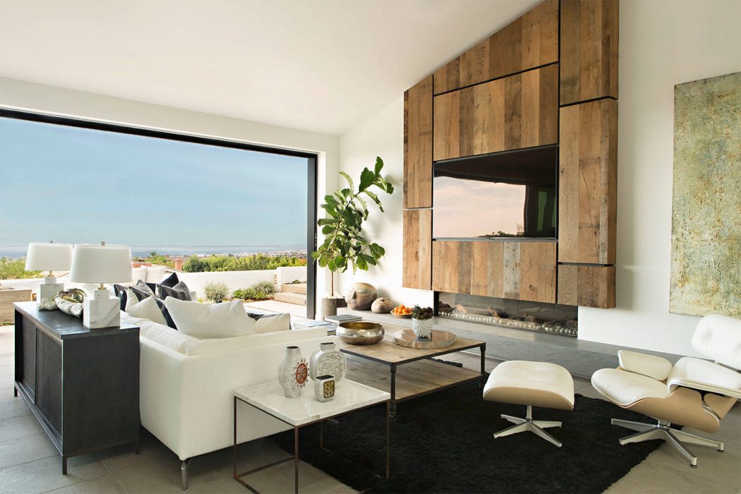 Spacious living room with large windows, wooden accent wall, and modern furniture.