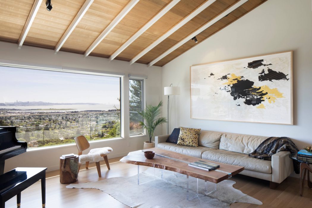 Cozy living room with wooden ceiling, large window, and modern abstract art.