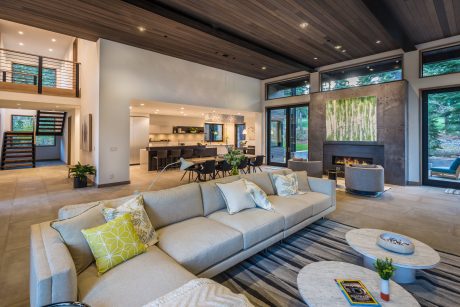 Spacious, modern living room with high ceilings, large windows, and artfully designed furniture.