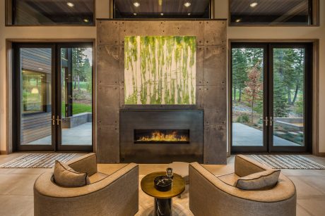 Sleek modern fireplace with concrete surround, wood-framed windows, and plush seating.