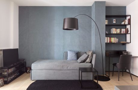 Minimal, modern living room with sleek furniture, a floor lamp, and built-in shelving.