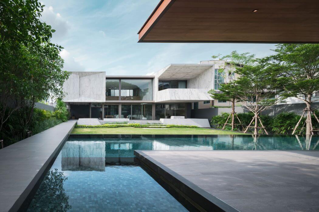 Sleek, modern architecture with reflecting pool, lush landscaping, and glass facades.