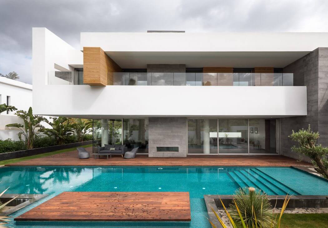 Modern, sleek architecture with a large glass-walled living space, wooden deck, and swimming pool.
