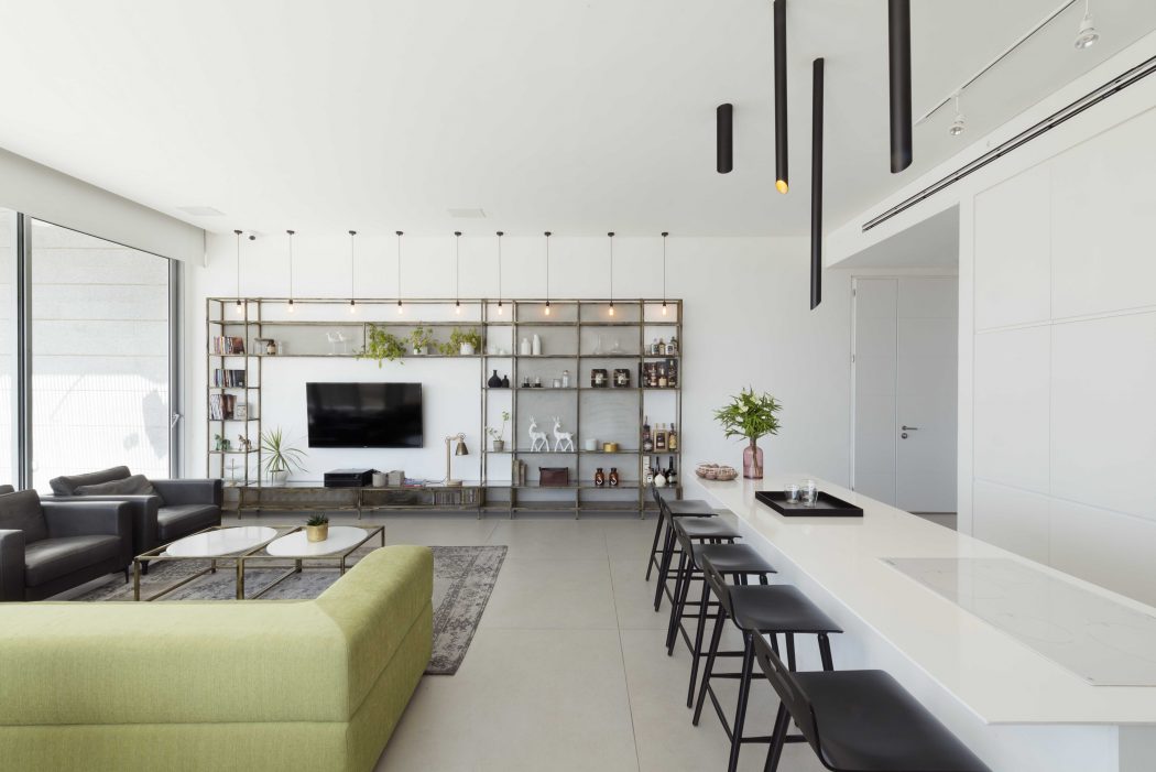 Modern and minimalist living space with sleek furniture, shelving, and lighting fixtures.