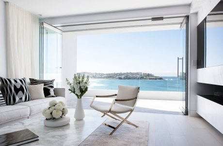 Minimalist living room with panoramic ocean view and modern furniture design.