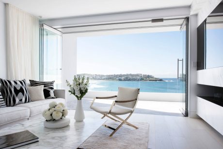 Minimalist living room with panoramic ocean view and modern furniture design.