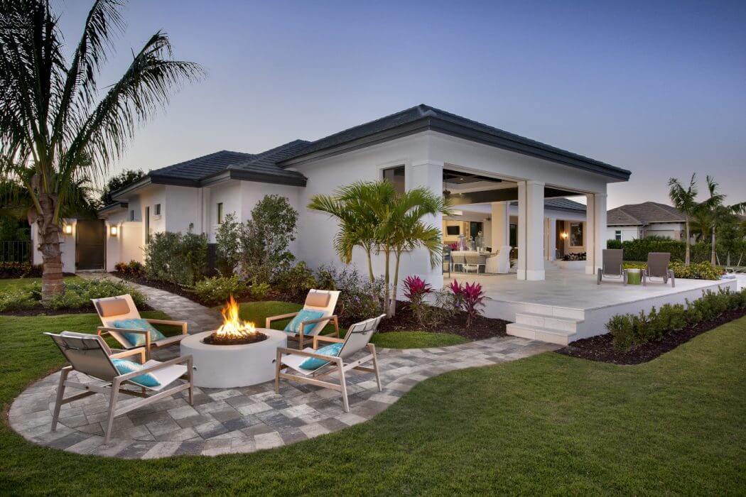 Elegant tropical-style residence with striking roofline, lush landscaping, and chic outdoor living area.