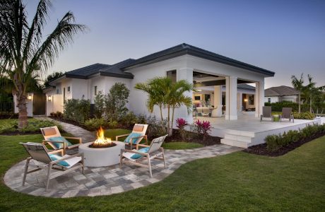 Elegant tropical-style residence with striking roofline, lush landscaping, and chic outdoor living area.