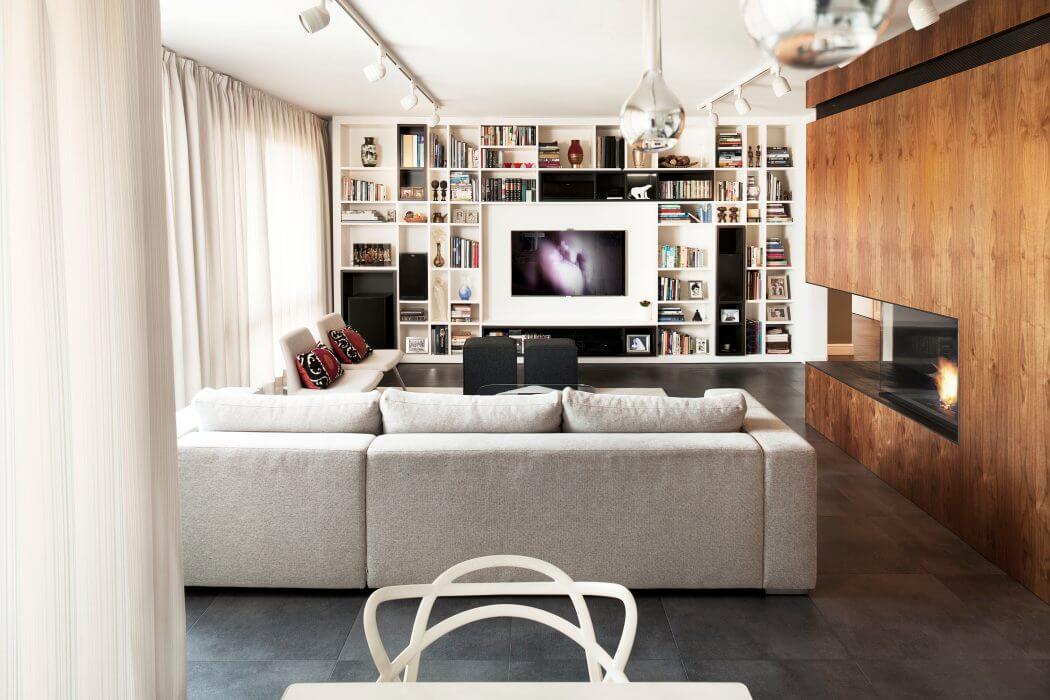 A cozy living room with a large, built-in bookshelf that serves as a media center.