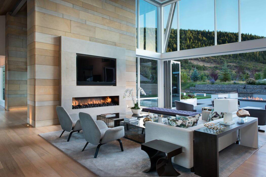 Expansive glass walls frame a stunning mountain landscape, complementing the modern interior.