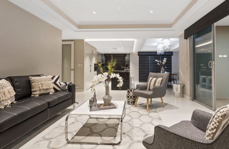 Modern and spacious living room with sleek furniture, patterned rug, and elegant lighting.