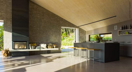 Large, open-concept kitchen with stone walls, wood ceiling, and modern appliances.